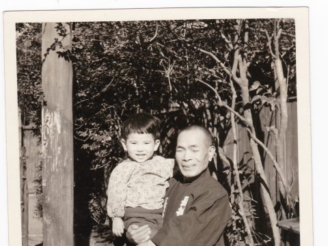 No.821 Juzo Takahashi (landscaping business) holding his first grandchild on the public road in front of his home